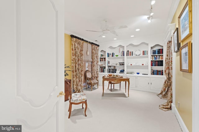 interior space with carpet, built in shelves, ceiling fan, and ornamental molding