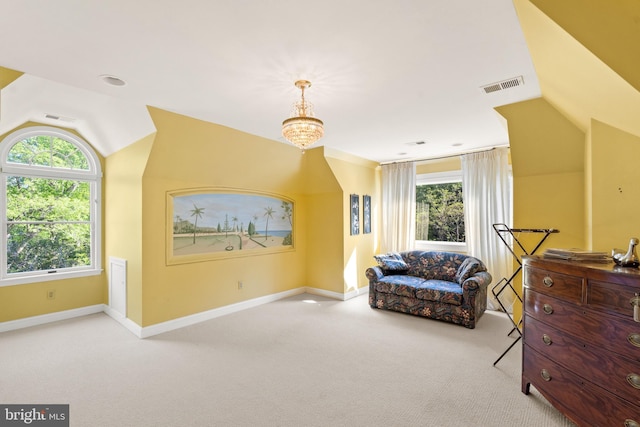 living area with light carpet, vaulted ceiling, and a notable chandelier