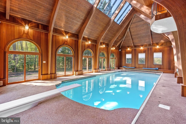 view of swimming pool with a skylight and a diving board