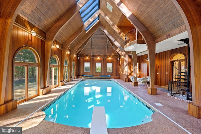 view of pool featuring a diving board and a skylight