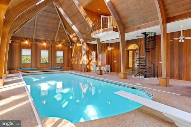 view of swimming pool with ceiling fan and a diving board