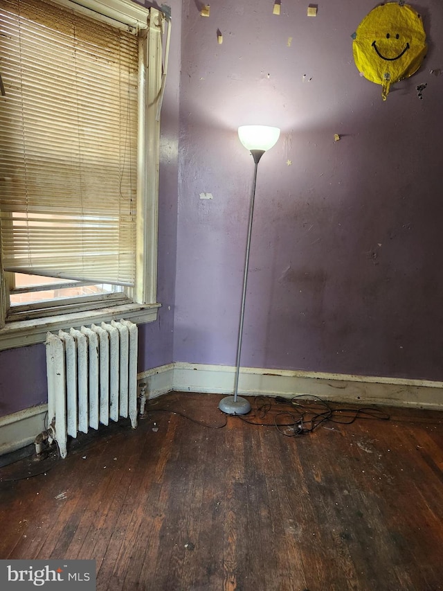 empty room with hardwood / wood-style floors and radiator