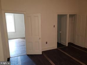 unfurnished bedroom with dark wood-type flooring