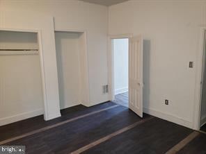 unfurnished bedroom with a closet and dark hardwood / wood-style flooring