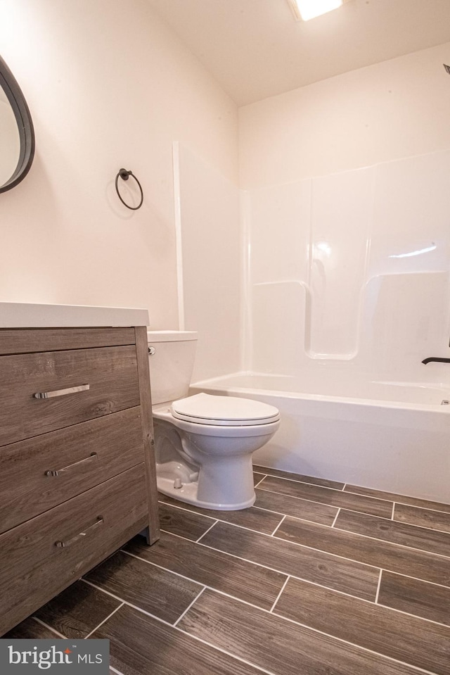 full bathroom featuring bathing tub / shower combination, vanity, and toilet