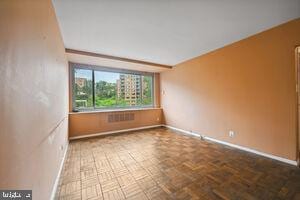 spare room featuring parquet flooring