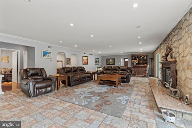 living room with ornamental molding and a fireplace