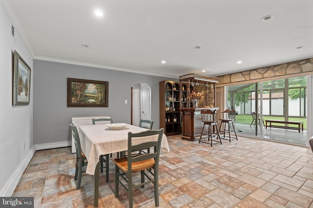 dining area featuring a baseboard radiator, bar, and crown molding