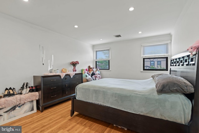 bedroom with light hardwood / wood-style flooring and ornamental molding