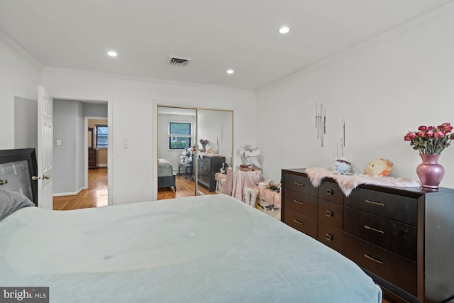 bedroom featuring ornamental molding, a closet, and light wood-type flooring