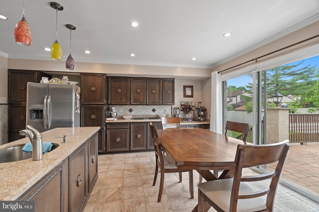 kitchen featuring decorative light fixtures, light stone countertops, stainless steel fridge with ice dispenser, and dark brown cabinets