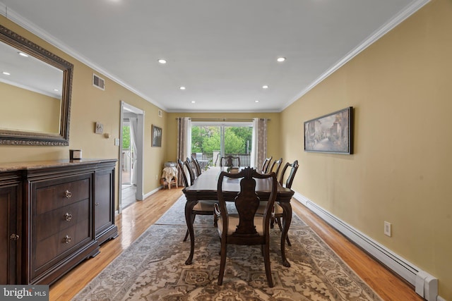 dining room with crown molding, baseboard heating, and light hardwood / wood-style floors