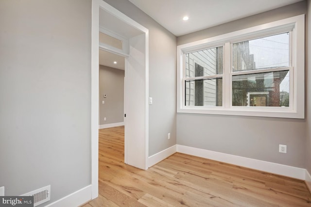 spare room featuring a healthy amount of sunlight and light hardwood / wood-style floors