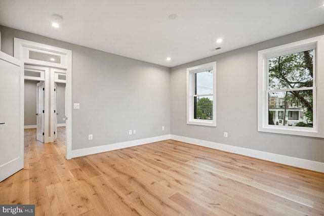 unfurnished room featuring a healthy amount of sunlight and light wood-type flooring