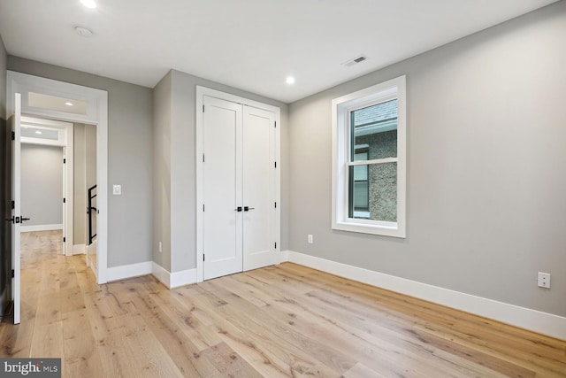 unfurnished bedroom featuring a closet and light hardwood / wood-style floors