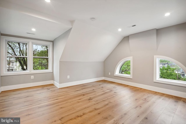 bonus room with vaulted ceiling and light hardwood / wood-style flooring