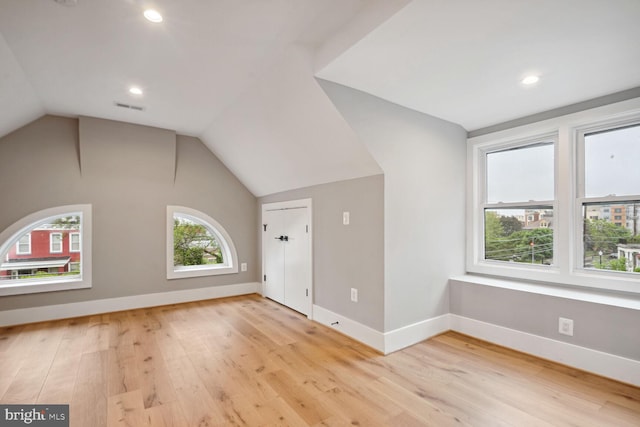 additional living space with light wood-type flooring and lofted ceiling