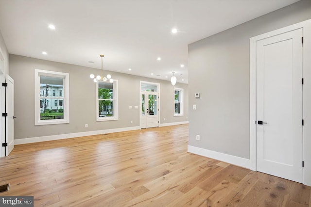 interior space with an inviting chandelier and light hardwood / wood-style flooring