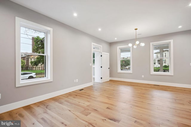 interior space featuring an inviting chandelier, plenty of natural light, and light hardwood / wood-style flooring