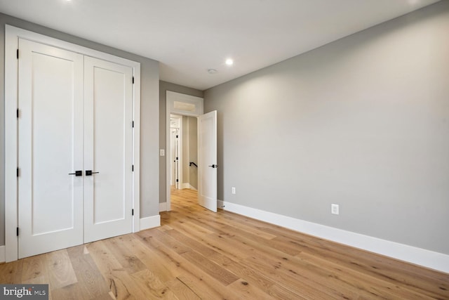 unfurnished bedroom with a closet and light wood-type flooring