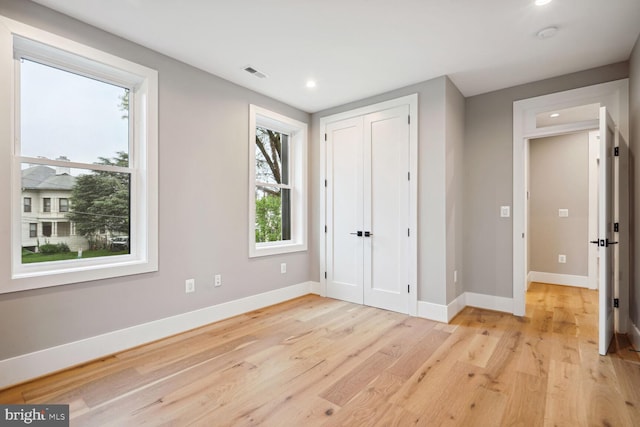 unfurnished bedroom featuring a closet and light wood-type flooring