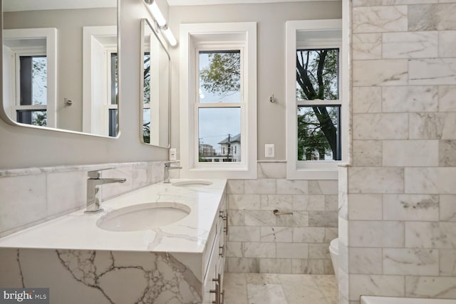 bathroom with tile floors, large vanity, toilet, and dual sinks