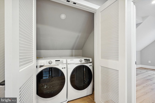 laundry room with light wood-type flooring and washing machine and clothes dryer