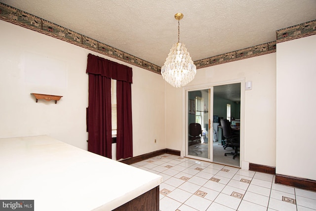 unfurnished dining area featuring an inviting chandelier, a textured ceiling, and light tile floors