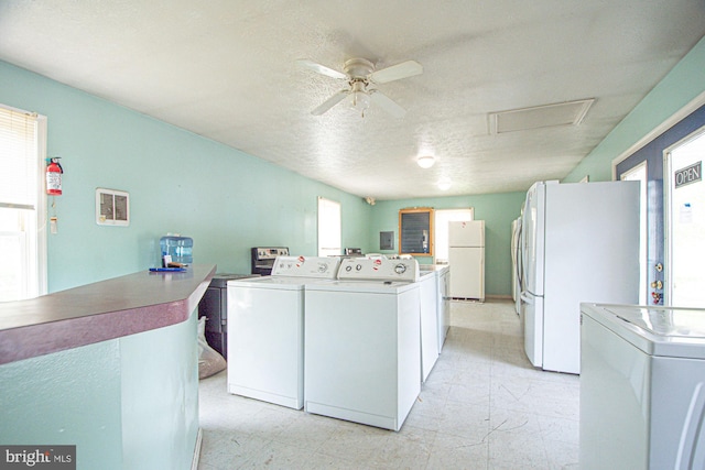 laundry room with light tile flooring, a textured ceiling, washer and clothes dryer, plenty of natural light, and ceiling fan