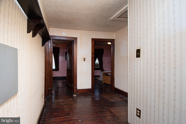 hall featuring a textured ceiling and dark wood-type flooring