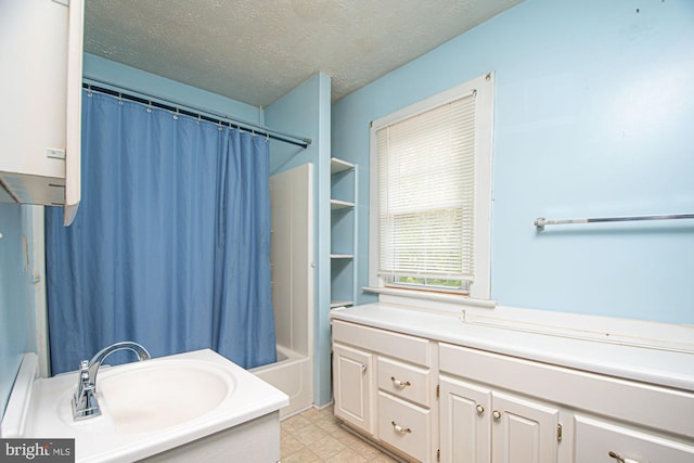 bathroom featuring tile floors, a textured ceiling, vanity, and shower / tub combo with curtain