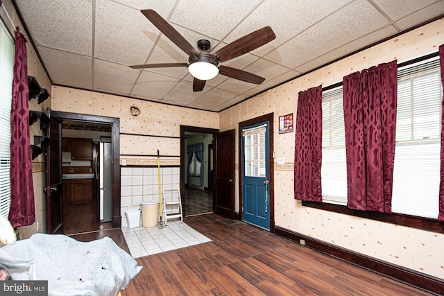 interior space featuring stainless steel refrigerator, dark wood-type flooring, and a paneled ceiling