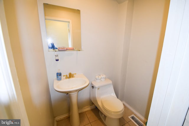 bathroom featuring sink, toilet, and tile floors