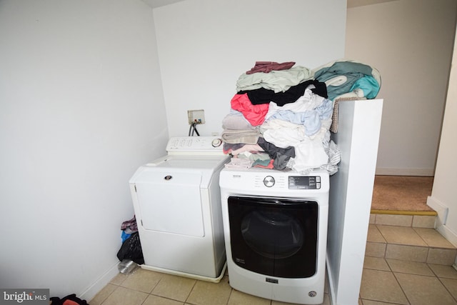 washroom featuring hookup for a washing machine, washer and clothes dryer, and light tile flooring