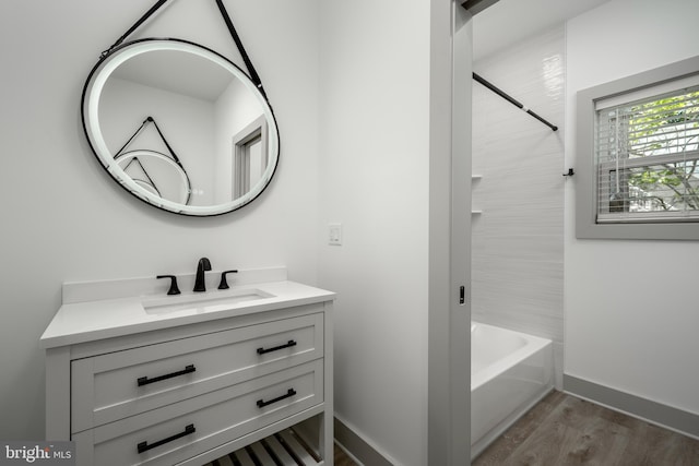 bathroom featuring tiled shower / bath combo, hardwood / wood-style floors, and vanity