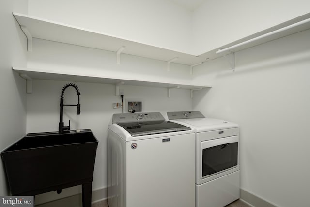 clothes washing area with washer and dryer, sink, and washer hookup