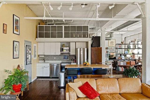 living room with dark hardwood / wood-style flooring and a towering ceiling