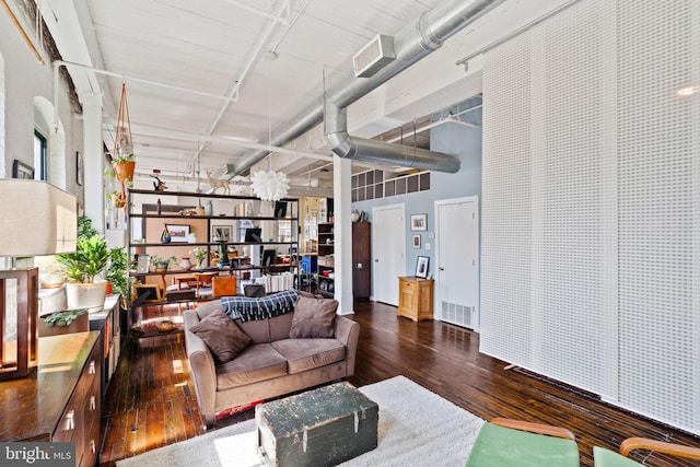 living room with dark hardwood / wood-style floors and a high ceiling