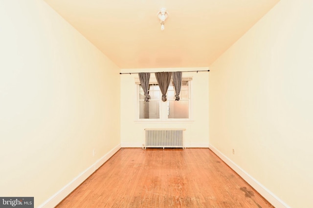 spare room featuring hardwood / wood-style flooring and radiator