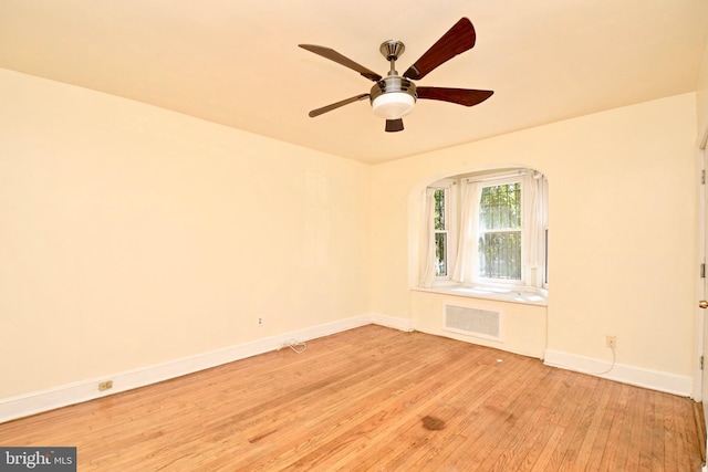 unfurnished room featuring radiator, ceiling fan, and light wood-type flooring