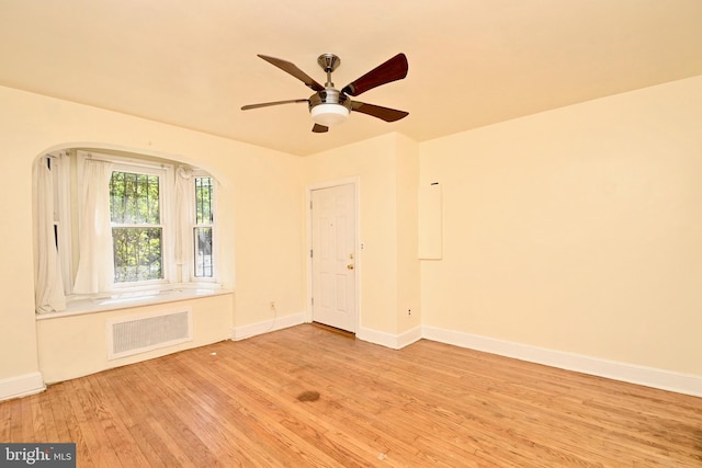 unfurnished room featuring ceiling fan, light hardwood / wood-style floors, and radiator