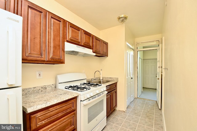 kitchen featuring light stone countertops, sink, light tile flooring, and white appliances