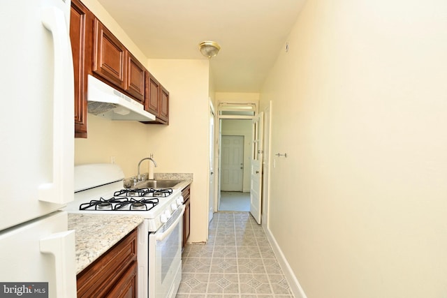 kitchen with sink, light stone counters, white appliances, and light tile floors