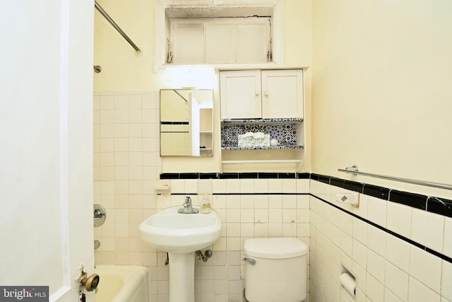 bathroom with tile walls, toilet, and shower / bathtub combination