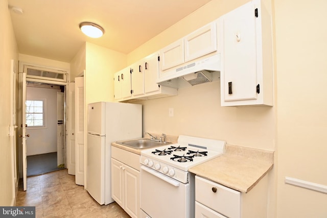 kitchen with white appliances, light tile flooring, custom range hood, sink, and white cabinetry