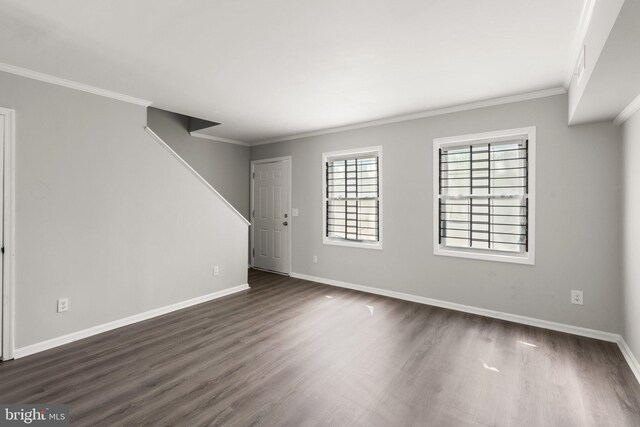 empty room with ornamental molding and dark wood-type flooring