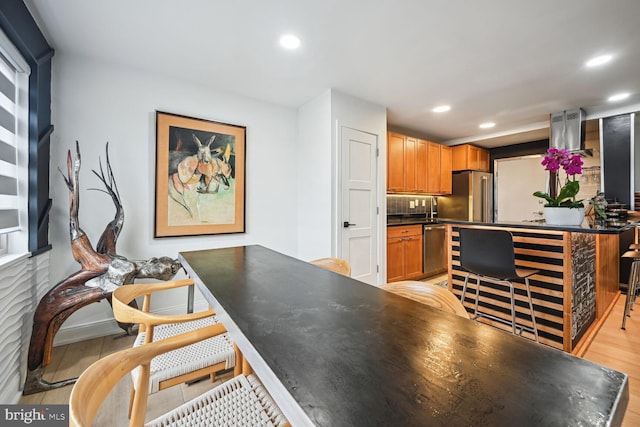 kitchen featuring stainless steel appliances, tasteful backsplash, and light wood-type flooring