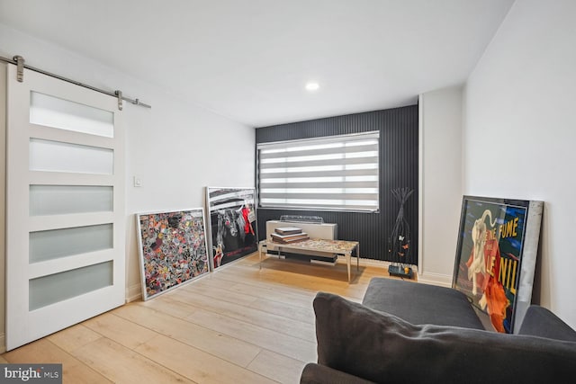 living room with a barn door and wood-type flooring