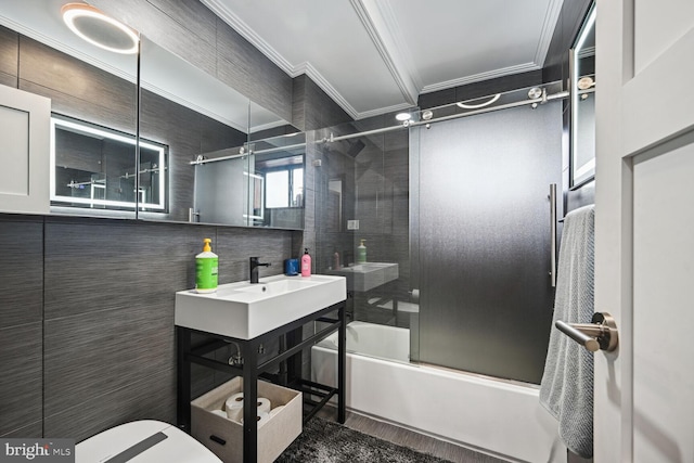 full bathroom featuring ornamental molding, enclosed tub / shower combo, tile walls, large vanity, and toilet