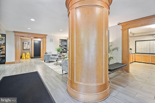 interior space featuring ornate columns and light hardwood / wood-style floors